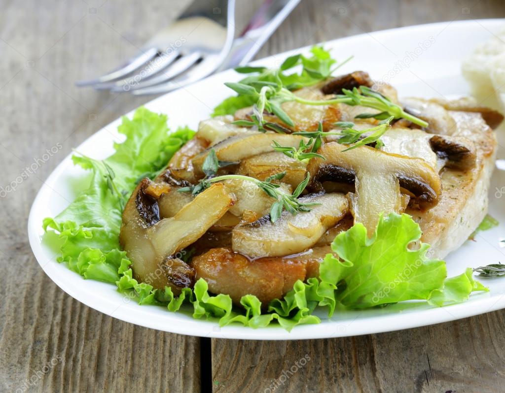 Pork steak with mushroom sauce on a white plate