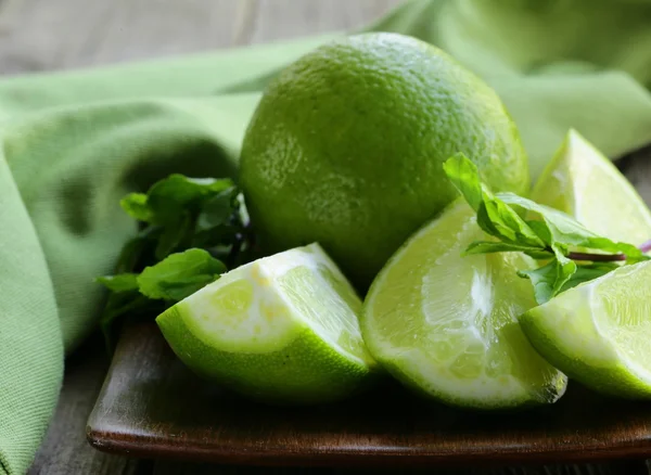 Fresh limes with green mint - chopped and whole — Stock Photo, Image