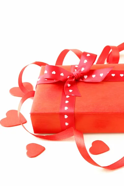 Червона подарункова коробка зі стрічкою та серцями на білому тлі — стокове фото