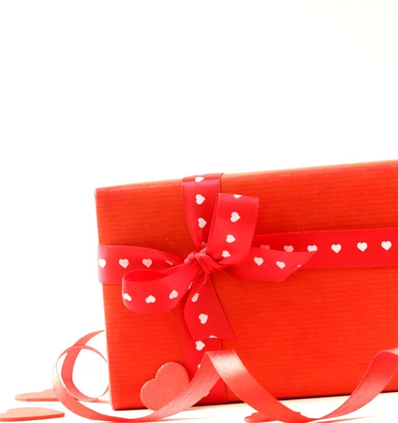 Scatola regalo rossa con nastro e cuori su sfondo bianco — Foto Stock