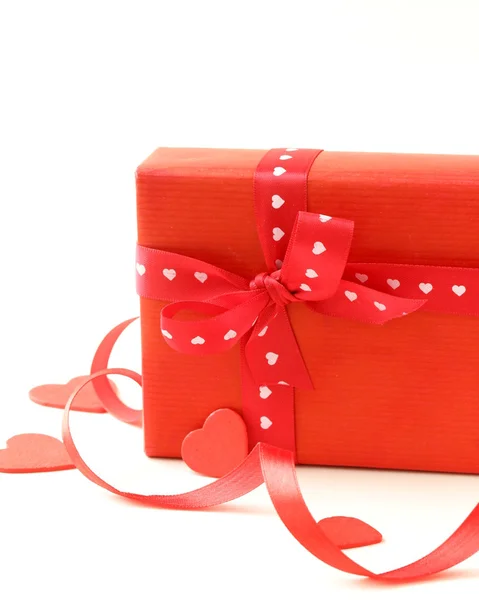 Caixa de presente vermelho com fita e corações em um fundo branco — Fotografia de Stock