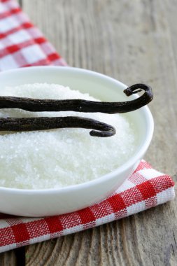 Sugar with natural vanilla pods in a cup clipart