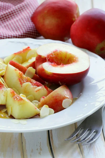 Літній фруктовий десерт з персиками, мигдалем та медом — стокове фото