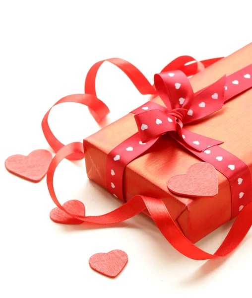 Červená dárková krabička s pásky a srdce na bílém pozadí — Stock fotografie