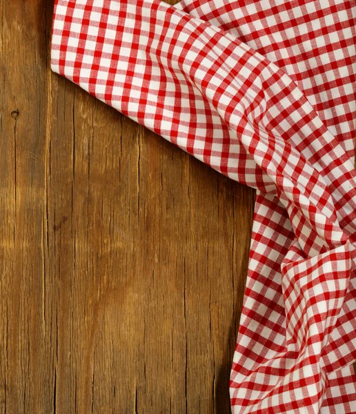 Houten achtergrond met rode geruite keuken handdoek — Stockfoto