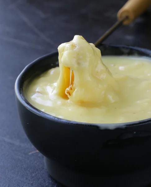 Fondue τυριών - κομμάτι ψωμί (κρουτόν) σε ένα υγρό τυρί — Φωτογραφία Αρχείου