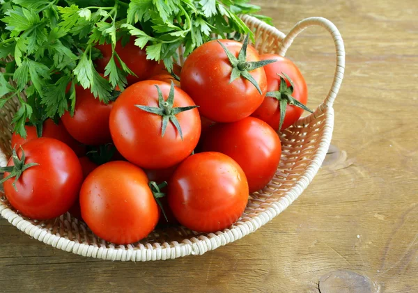 Tomates maduros frescos em uma cesta na mesa — Fotografia de Stock