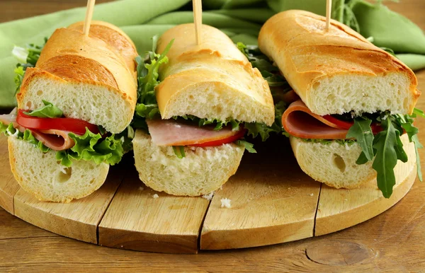 Baguette sandwich with arugula, ham and tomatoes — Stock Photo, Image