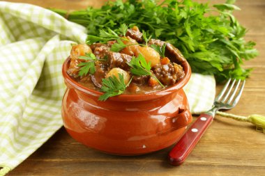 Beef stew with vegetables and herbs in a clay pot - comfort food clipart