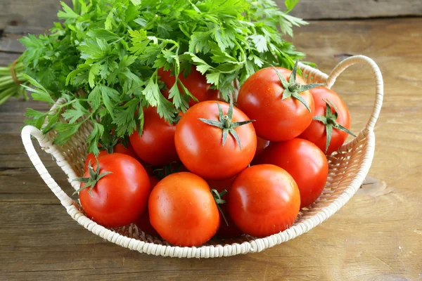 Frische reife Tomaten in einem Korb auf dem Tisch — Stockfoto