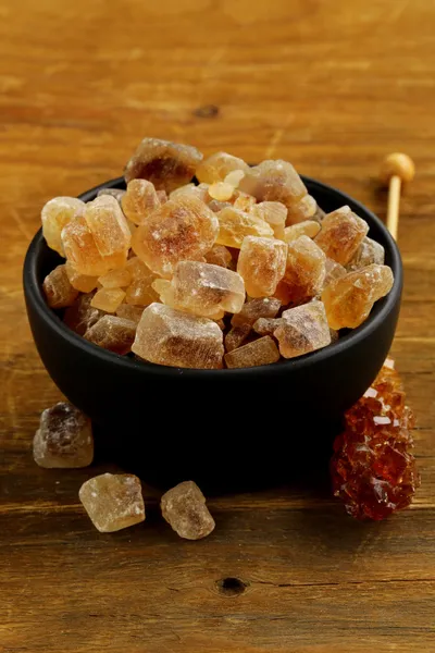 Rock candy cukru v šálku na dřevěný stůl — Stock fotografie