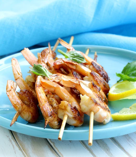 Shrimp grilled on wooden skewers with lemon and basil — Stock Photo, Image