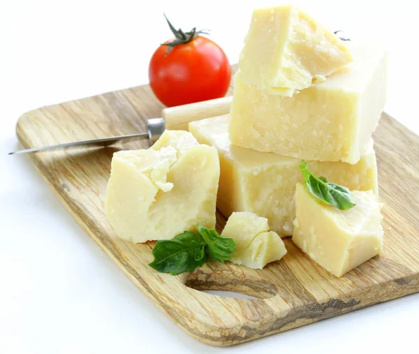 Queso parmesano natural duro sobre una tabla de madera —  Fotos de Stock