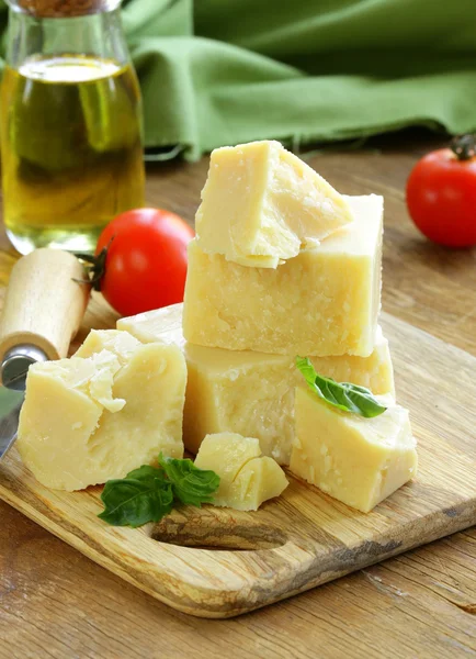 Queso parmesano natural duro sobre una tabla de madera —  Fotos de Stock