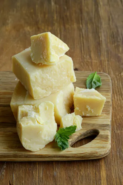 Tvrdý přírodní sýr parmezán na dřevěném prkénku — Stock fotografie