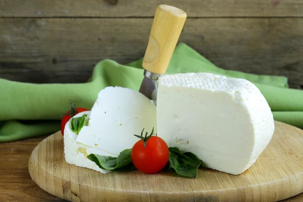 Gezouten melk kaas (fetakaas) op een houten snijplank — Stockfoto