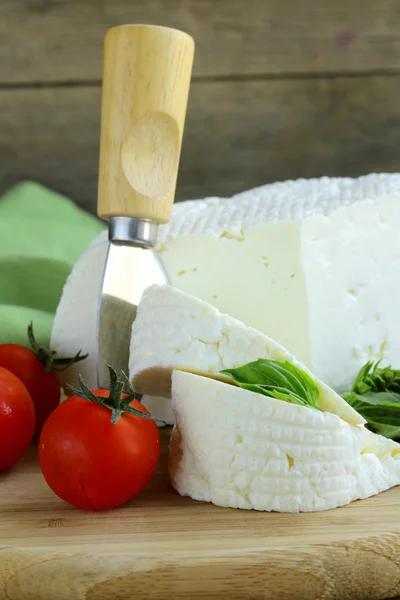 Queijo de leite salgado (queijo feta) em uma tábua de corte de madeira — Fotografia de Stock