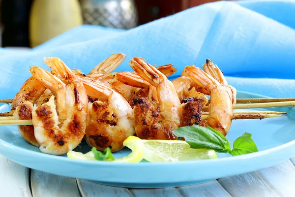 Shrimp grilled on wooden skewers with lemon and basil — Stock Photo, Image