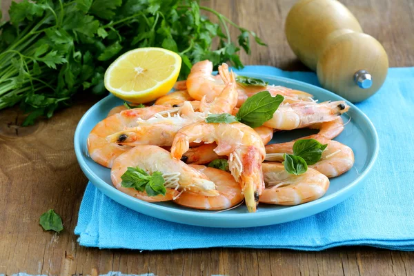 Camarones cocidos con limón y albahaca sobre una mesa de madera —  Fotos de Stock