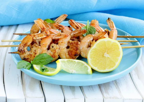 Shrimp grilled on wooden skewers with lemon and basil — Stock Photo, Image