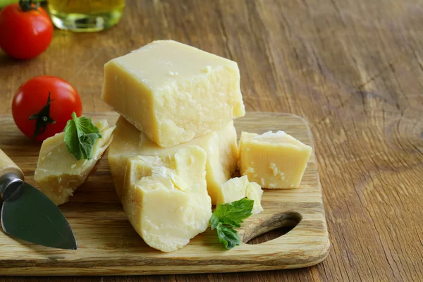Tvrdý přírodní sýr parmezán na dřevěném prkénku — Stock fotografie