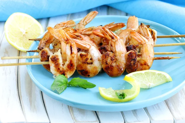 Shrimp grilled on wooden skewers with lemon and basil — Stock Photo, Image