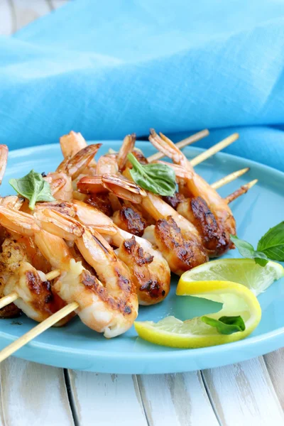 Shrimp grilled on wooden skewers with lemon and basil — Stock Photo, Image