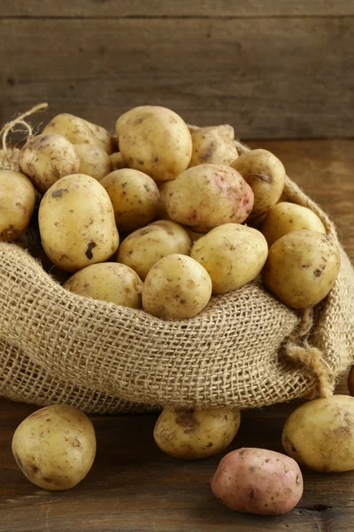 Fresh organic potatoes on a wooden background, rustic style — Stock Photo, Image