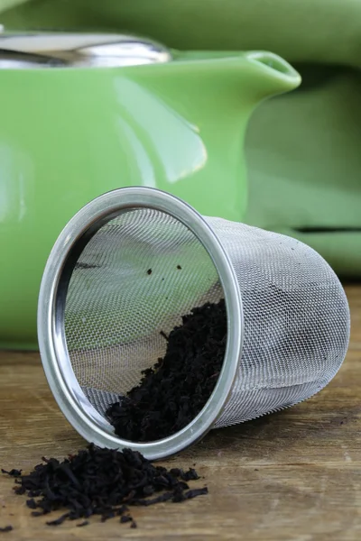 Granulated black tea in a metal cup on a wooden table — Stock Photo, Image