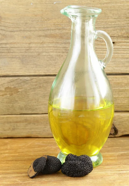 Оливкова олія, приправлена чорним трюфелем на дерев'яному столі — стокове фото