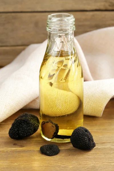 Оливкова олія, приправлена чорним трюфелем на дерев'яному столі — стокове фото