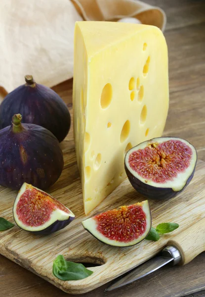 Piece of cheese (Maasdam) with fresh figs on a wooden board — Stock Photo, Image
