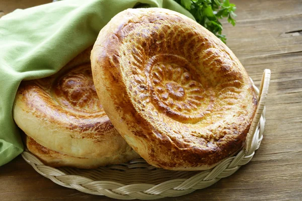 Geleneksel Orta Asya ekmek, ekmeği ahşap bir masa üzerinde kazık. — Stok fotoğraf