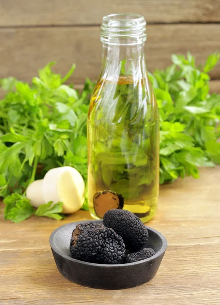 Olive oil flavored with black truffle on a wooden table — Stock Photo, Image