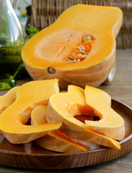 Fresh raw pumpkin sliced on a wooden table — Stock Photo, Image
