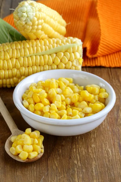 Canned corn in a bowl, and fresh cobs — Stock Photo, Image