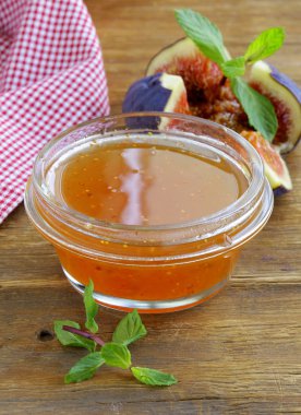 incir reçeli tahta masanın üzerine taze çilek ile