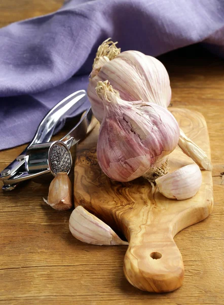 Whole garlic bulbs on a cutting board — Stock Photo, Image