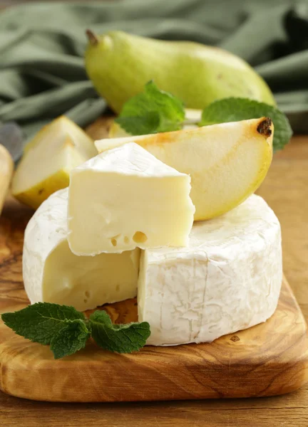 Soft brie cheese (camembert) with pears on a wooden board — Stock Photo, Image