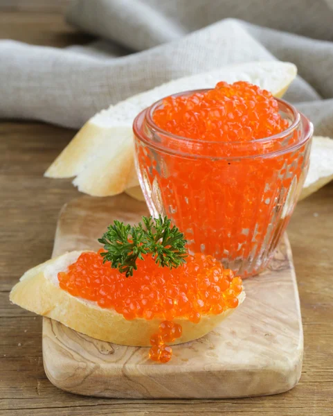 Delicado aperitivo caviar rojo en una baguette blanca — Foto de Stock