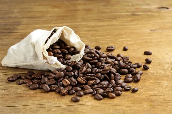 Roasted coffee beans on a wooden table — Stock Photo, Image