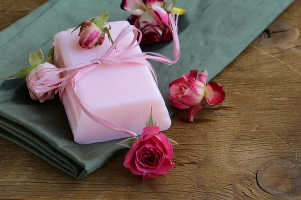 Zelfgemaakte zeep met rozen op een houten tafel — Stockfoto