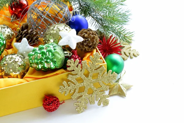 Christmas decorations (balls, cones, stars) in the yellow box — Stock Photo, Image