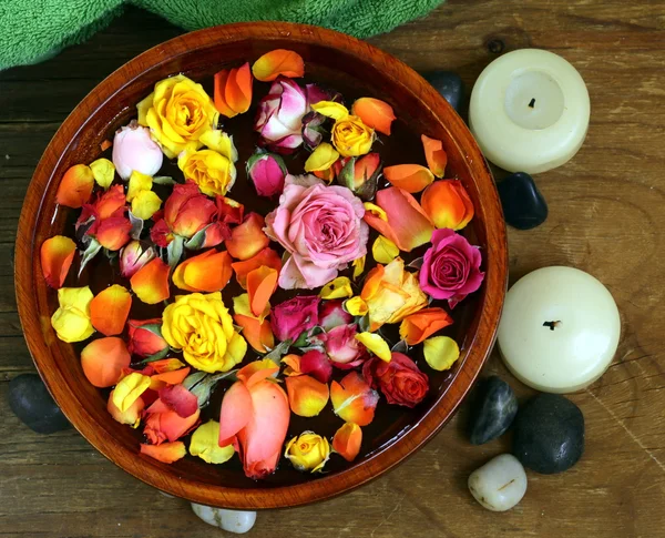 Wooden bowl with roses and petals of flowers - spa concept — Stock Photo, Image