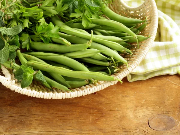 Haricots verts frais sur une table en bois — Photo