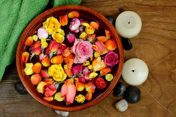 Wooden bowl with roses and petals of flowers - spa concept — Stock Photo, Image