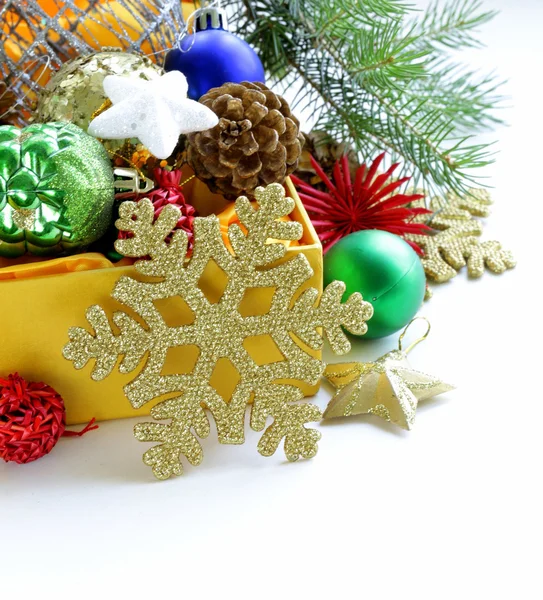 Decoraciones navideñas (bolas, conos, estrellas) en la caja amarilla —  Fotos de Stock