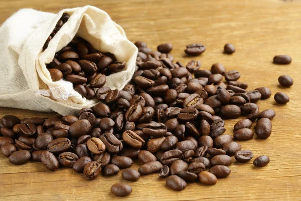 Roasted coffee beans on a wooden table — Stock Photo, Image