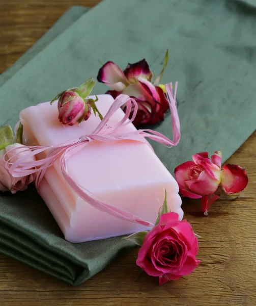 Домашнее мыло с розами на деревянном столе — стоковое фото
