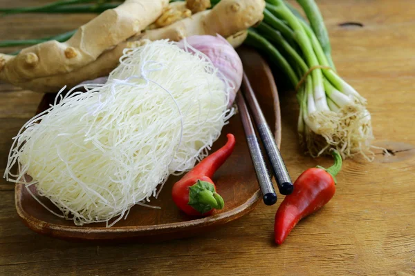 Asian food ingredients - rice noodles, ginger, chili pepper, garlic — Stock Photo, Image